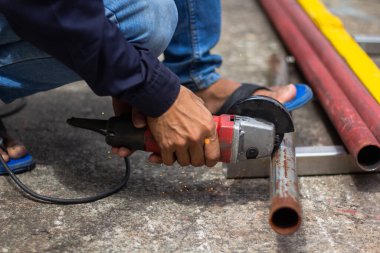 İş yerinde güvenlik eldiveni olmadan. İnşaat işçileri çalışırken eldiven ve güvenlik ayakkabısı giymezler. İş yeri güvenli değil.