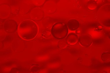 Kırmızı parıltılı klasik ışıklar arka planda. Kırmızı doku arka planı. Suya yağ damlıyor..