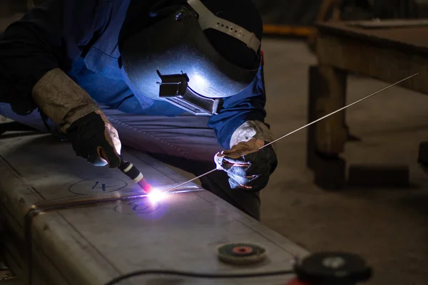 Metal workers use manual labor, Skilled welder, Factory workers making OT. Welder is welding the steel in the factory.