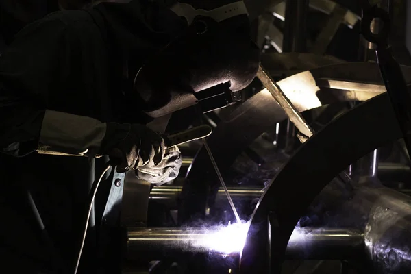 Metal workers use manual labor, Skilled welder, Factory workers making OT. Welder is welding the steel in the factory.