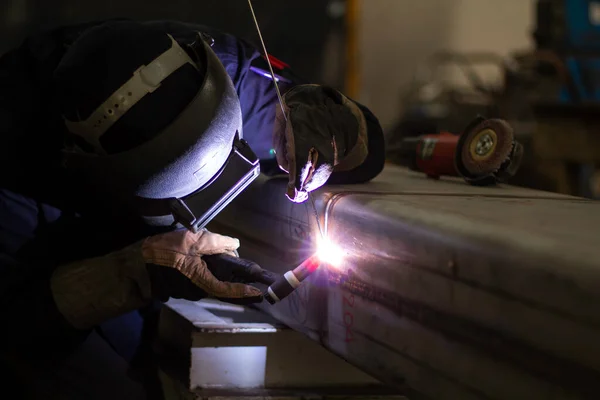 Metal workers use manual labor, Skilled welder, Factory workers making OT. Welder is welding the steel in the factory.