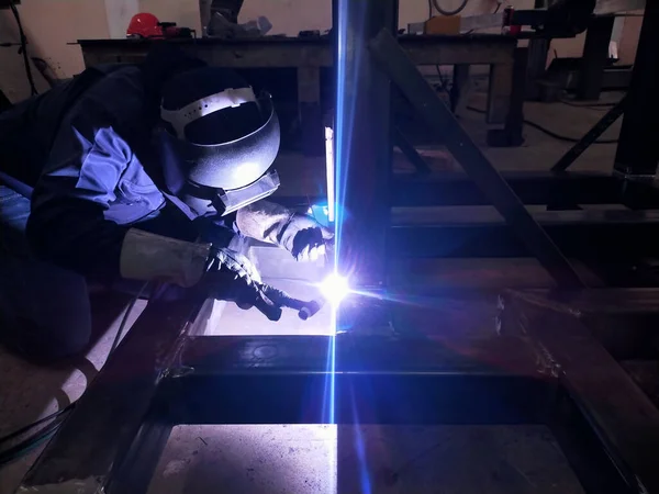 Metal workers use manual labor, Skilled welder, Factory workers making OT. Welder is welding the steel in the factory.