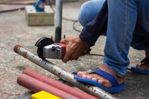 İş yerinde güvenlik eldiveni olmadan. İnşaat işçileri çalışırken eldiven ve güvenlik ayakkabısı giymezler. İş yeri güvenli değil.