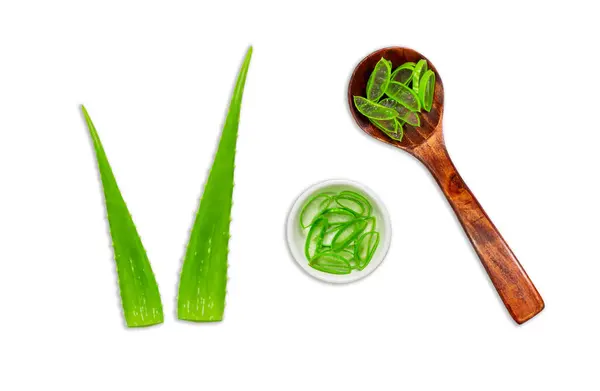 Aloe vera yaprakları ve beyaz arka planda izole edilmiş tahta kaşıkla dilimlenmiş..
