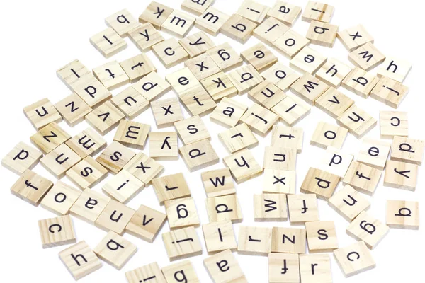 Kare tahta fayanslardan yapılmış İngiliz alfabesi beyaz zemin üzerine dağılmış. Düşünce geliştirme konsepti, dil bilgisi.
