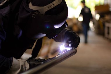 Metal işçileri amelelik yapar. Yetenekli kaynakçı. Fabrika işçileri mesai yapıyor. Kaynakçı fabrikadaki çeliği kaynaklıyor. Kaynakçı Endüstriyel Otomotiv Fabrikası.