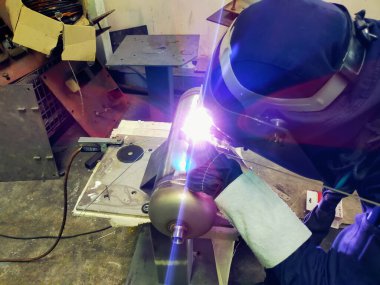 Metal işçileri amelelik yapar. Yetenekli kaynakçı. Fabrika işçileri mesai yapıyor. Kaynakçı fabrikadaki çeliği kaynaklıyor. Kaynakçı Endüstriyel Otomotiv Fabrikası.