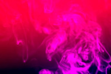 Bulanık mor dumanlı arka plan. Siyah arkaplanda renkli duman bulanıklaştı.