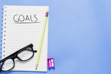 Not defteri ve kalem beyaz arka plana yerleştirilmiş. Hedefli, planlı defter.