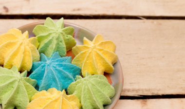 Tatlı, çıtır çıtır, çok renkli, ahşap arka planda bir tabakta. Fotoğraf..