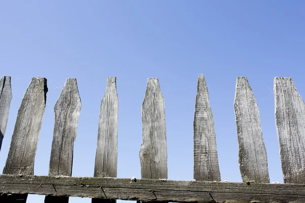 Houten hek tegen de blauwe hemel. Achtergrond. — Stockfoto