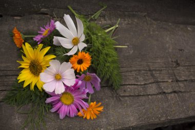 Bir ahşap tahta üzerinde renkli çiçekler buket. Fotoğraf.