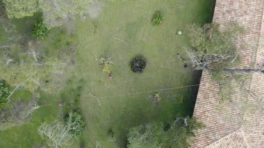 Ağaç üzerinde çalışan bir ağaç ustası ve yerde güvenlik önlemleriyle çalışan işçiler ile yükseklikte kesilip budamak. Halatlar, makaralar, emniyet kemerleri, kask, kesim önleyici botlar ve eldivenler kullanılıyor. 11.