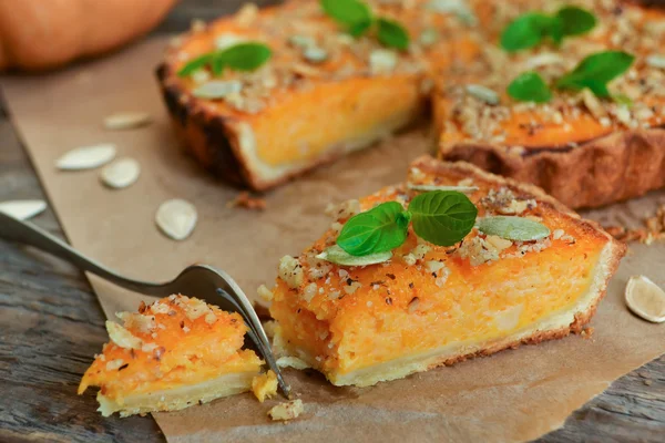 Pumpkin tart with cream and cinnamon on rustic background — Stock Photo, Image