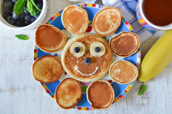 Sun for breakfast of pancakes with bananas and blueberries — Stock Photo, Image