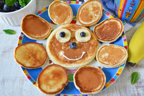 Sun for breakfast of pancakes with bananas and blueberries — Stock Photo, Image