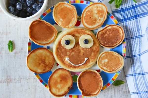 Sun for breakfast of pancakes with bananas and blueberries — Stock Photo, Image