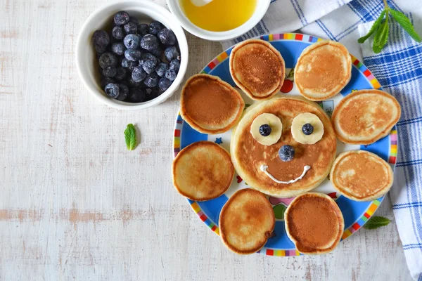 Sun for breakfast of pancakes with bananas and blueberries — Stock Photo, Image