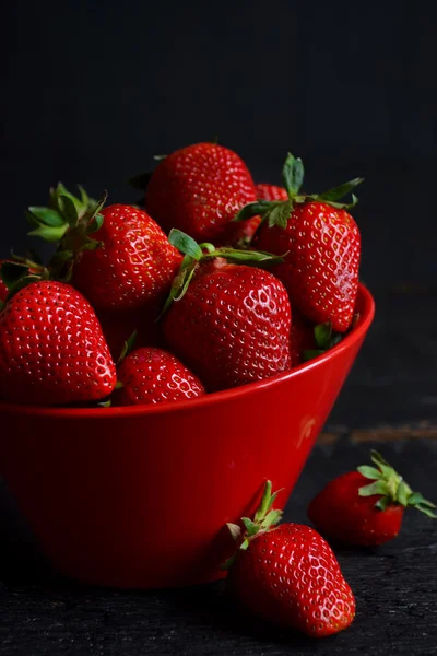 Juicy, fresh strawberries in a dish on a black background — Stock Photo, Image