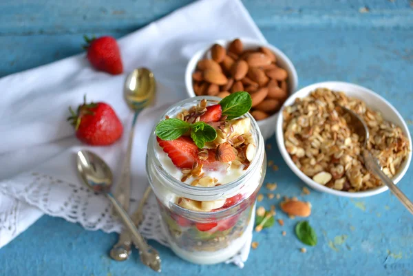 Oatmeal with yogurt, kiwi, banana, strawberries and almonds in a — Stock Photo, Image