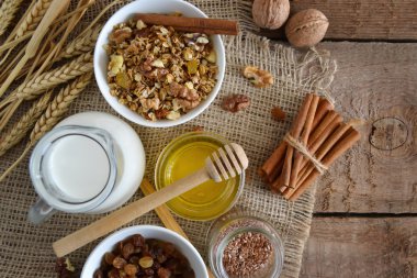 Ceviz, granola, süt ve bal ahşap arka plan üzerinde