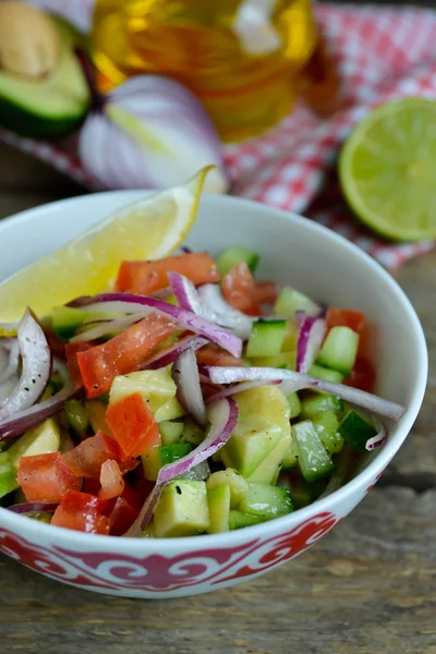 Avokado, domates ve ahşap zemin üzerine kireç ile salata — Stok fotoğraf