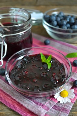 Böğürtlenli reçel ahşap arka plan üzerinde cam kavanozda