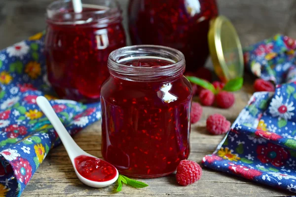 Confiture de framboise fraîche dans un bocal en verre sur un fond en bois — Photo