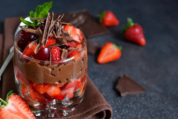 Postre con chocolate, fresas y crema en un vaso en un b — Foto de Stock