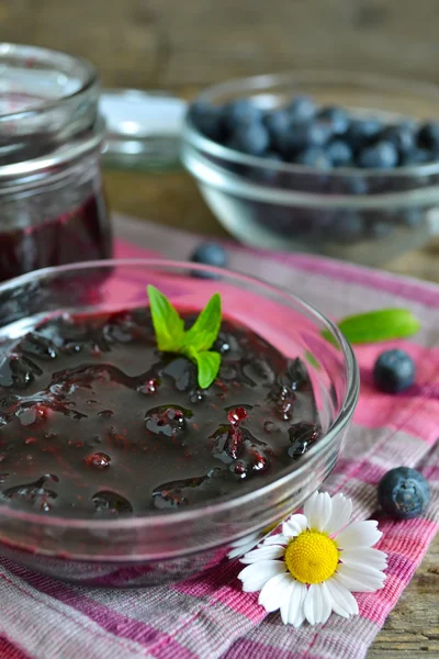 Confiture de bleuets dans un bocal en verre sur un fond en bois — Photo