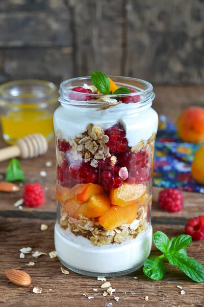 Homemade yogurt with granola, almonds, peaches and raspberries o — Stock Photo, Image