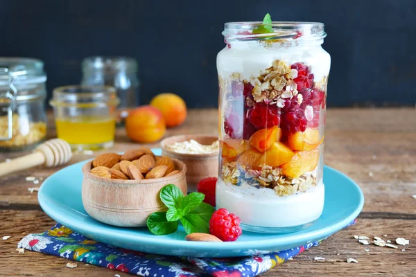 Zelfgemaakte yoghurt met muesli, amandelen, perziken en frambozen o — Stockfoto