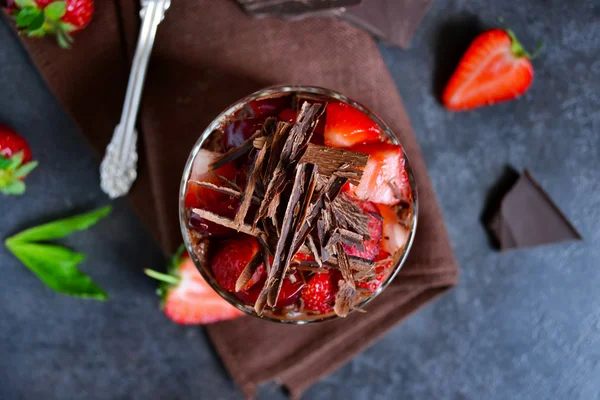 Dessert with chocolate, strawberries and cream in a glass on a b — Stock Photo, Image