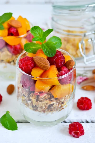 Homemade yogurt with granola apricots, peaches and raspberries o — Stock Photo, Image