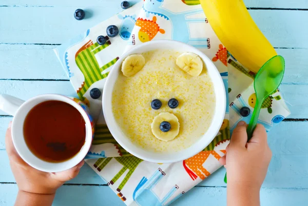 Kids breakfast, porridge with fruits and berries, face bears