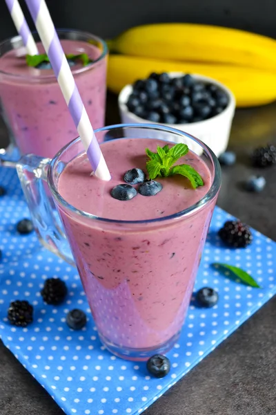 Smoothie with banana, blackberries and blueberries on a black ba — Stock Photo, Image