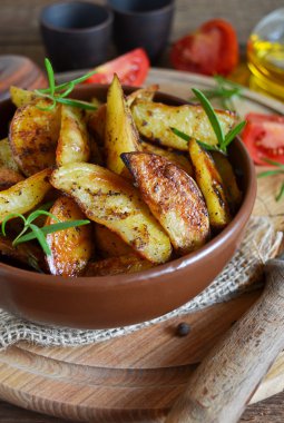 Fırında patates dilimleri biberiye ve ahşap backgro sarımsak ile