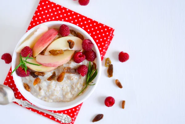 Ранковий сніданок, вівсянка з ягодами, персиками та родзинками — стокове фото