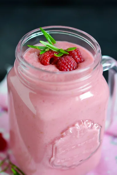 Summer cool drink, a smoothie with raspberry and peach on a blac