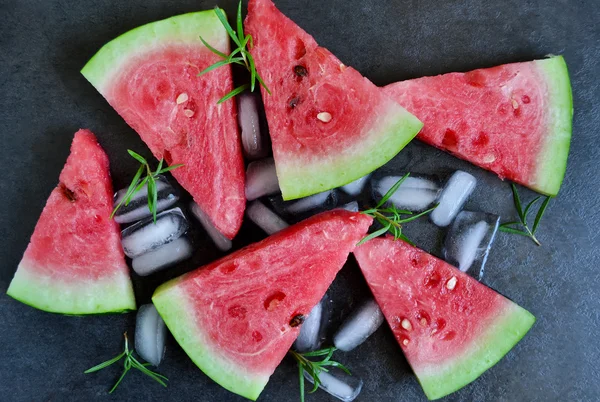 Fondo de rodajas de sandía fresca con hielo sobre un fondo negro —  Fotos de Stock