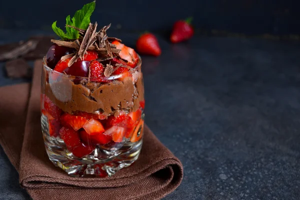 Dessert with chocolate, strawberries and cream in a glass on a b — Stock Photo, Image