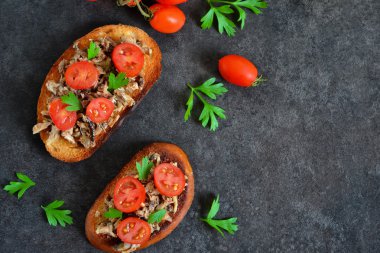 Hamsi, domates ve sarımsak ile siyah bir arka plan ile tost