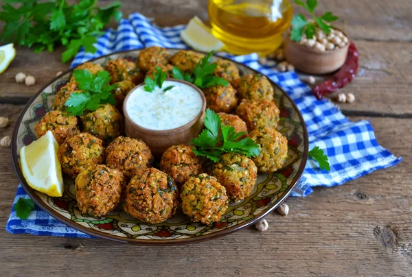 Falafel - frittierte Bällchen aus gemahlenen Kichererbsen mit Tahini-Sauce aus — Stockfoto