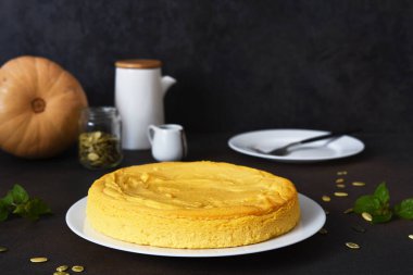 Koyu beton bir masada balkabaklı ev yapımı cheesecake. Yatay odak.