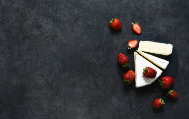 Çilekli peynir ve siyah mutfak masasında bal. Yukarıdan bak. Atıştırmalık.