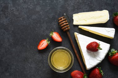 Çilekli peynir ve siyah mutfak masasında bal. Yukarıdan bak. Atıştırmalık.