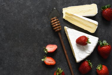 Çilekli peynir ve siyah mutfak masasında bal. Yukarıdan bak. Atıştırmalık.