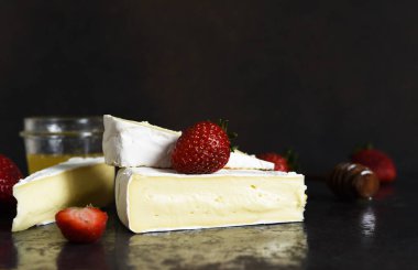 Çilekli peynir ve siyah mutfak masasında bal. Atıştırmalık Yatay odak.