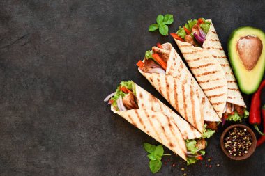 Meksika usulü ızgara tortilla. Arka planda tavuk göğsü ve sebze var.