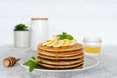 Mutfak masasında kahvaltıda ballı ve muzlu krep..